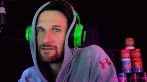man wearing neon green headphones in a dark room