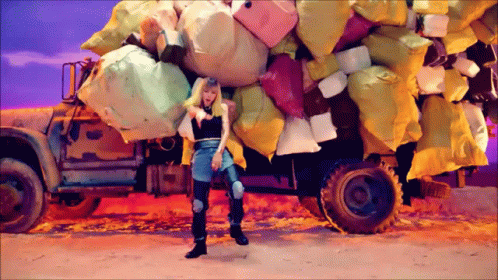 a girl holding a bunch of balloons by a truck