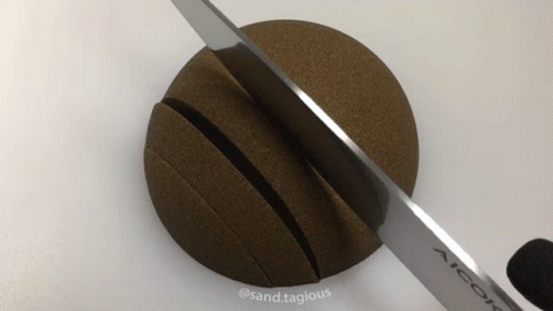 a knife and a ball laying on a white surface