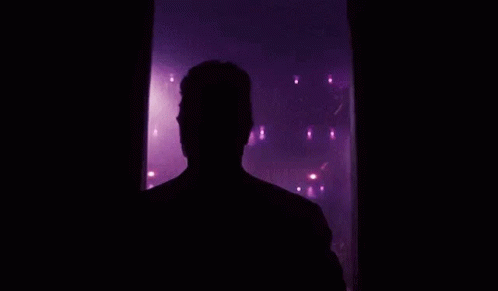a man that is standing in a darkened room