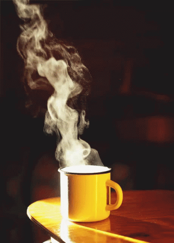 a cup with steam rising from it on a table