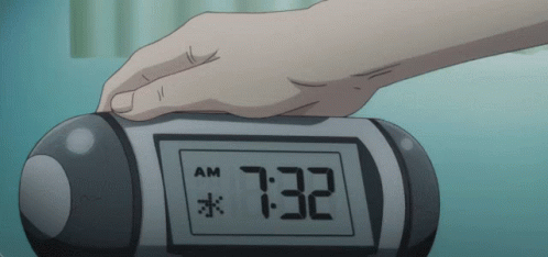 hand on alarm clock displaying time on screen
