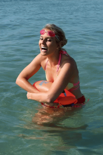a woman is in the water getting her face painted