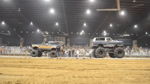 two large trucks performing a trick on huge trucks