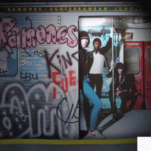 several people walking into an abandoned train car with graffiti