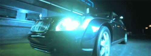 a very dimly lit bentley car with it's headlights turned on