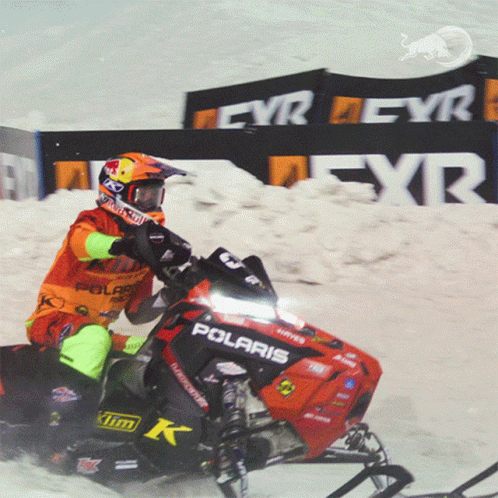 a man riding a snowmobile down a ski slope