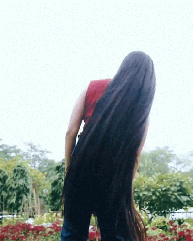 a woman standing with her long hair blowing in the wind