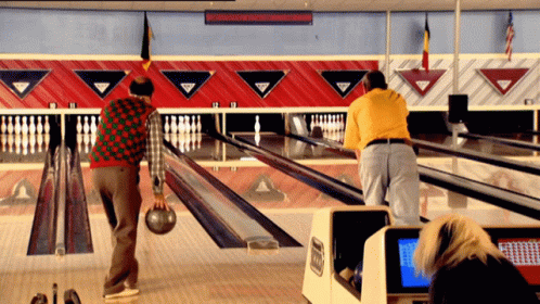 a bowling game is being watched by two people