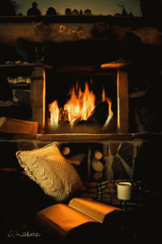 a couch with two pillows on it near a fire place