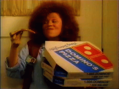 a woman is holding a pizza and two boxes