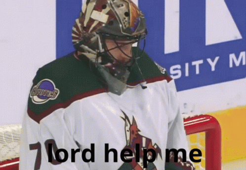 a hockey player is standing with his head in his hands