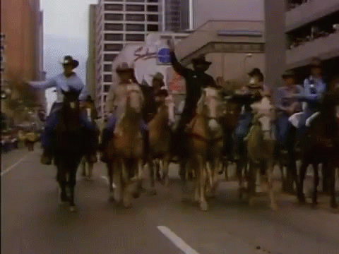 a large group of horse riders are on the street