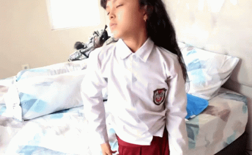 a  in a uniform standing on a bed