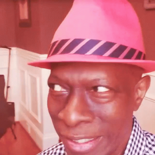 a man with a pink hat is looking at the camera