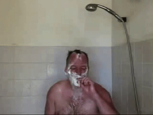 man with violet makeup and white shaving in the shower