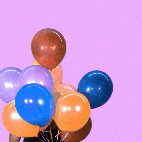 a bunch of balloons sticking out of a vase