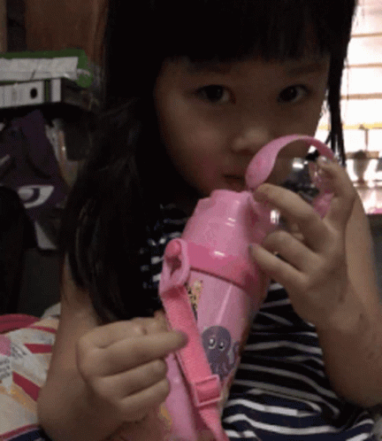 a young child holding a blender with one hand and the other hand