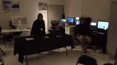 a person stands in a darkened room with a video game