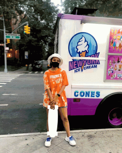 a woman in blue shirt standing by a large ice cream truck