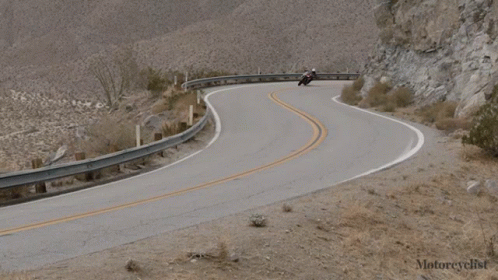 the curve in the road is near a mountain