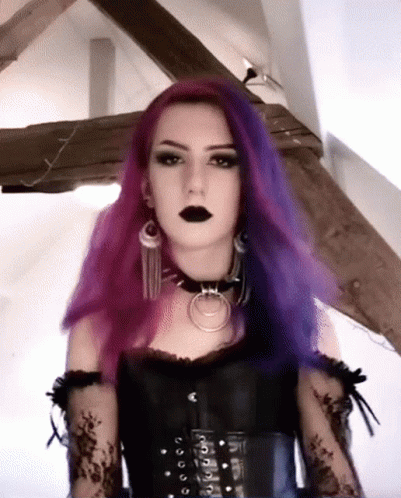 woman in a black corset and purple hair wearing a ring necklace