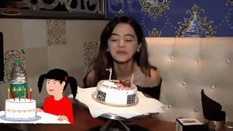 a woman with a birthday cake in front of her