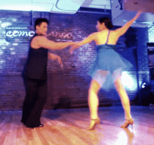 a woman in a yellow skirt and a man are dancing