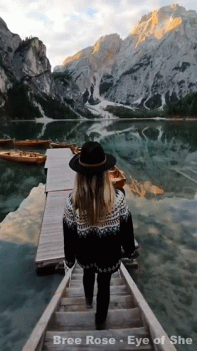 a person that is walking down a long wooden bridge