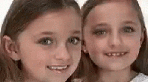 two girls with blueish makeup are posing for the camera