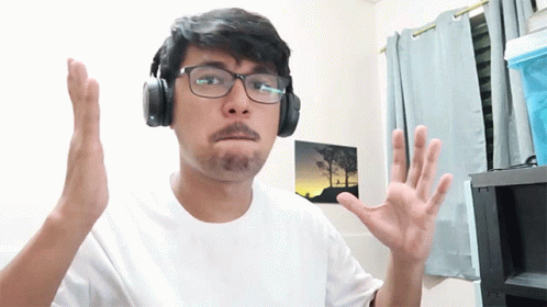 a man with glasses wearing headphones making gestures