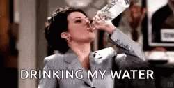 the woman is drinking from a water bottle