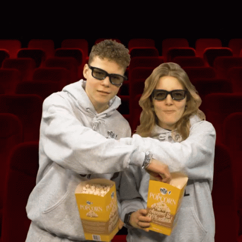 the couple in white are holding boxes of popcorn
