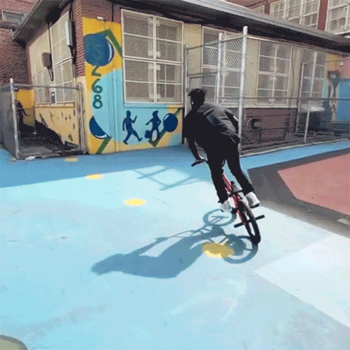 a man on a bike doing tricks outside a building