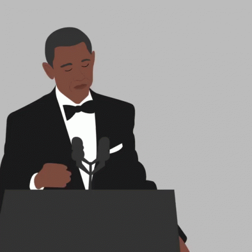 a man is speaking at a podium in a tuxedo