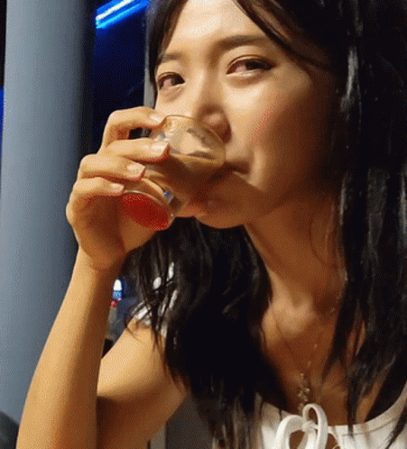 a young woman drinking soing blue at a party
