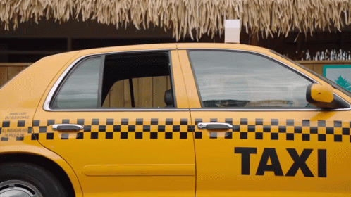 a taxi cab sitting in front of a blue building