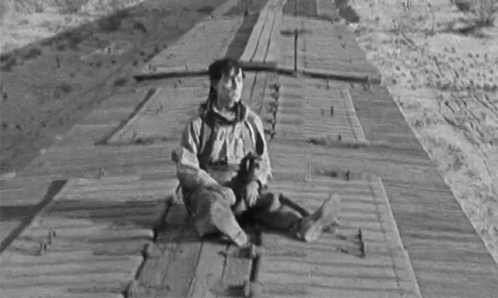 a man that is sitting down on the side of train