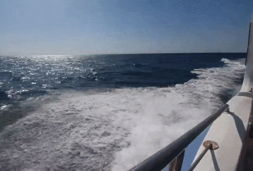 a view of the ocean from the back of a boat