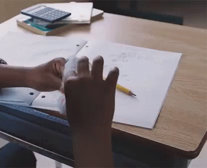 a person's hands are touching a paper on a desk