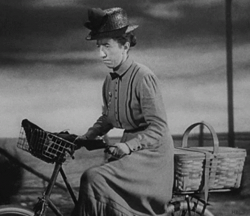 a woman riding on top of a bicycle near a basket