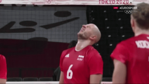 the players are wearing purple shirts while playing volleyball