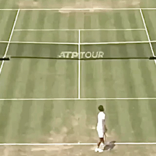a man walking across a tennis court holding a racquet