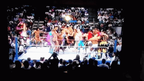a crowded wrestling ring is shown with a large group of people watching