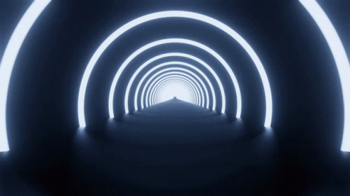 a tunnel with white lights on it has a white arrow pointing to it