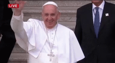 a man with glasses and a white pope waving