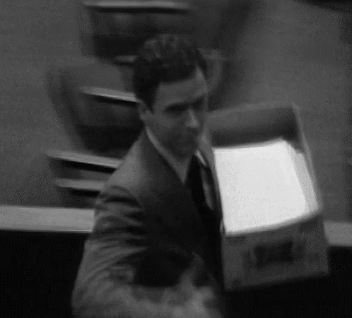 a man in a suit moving a box