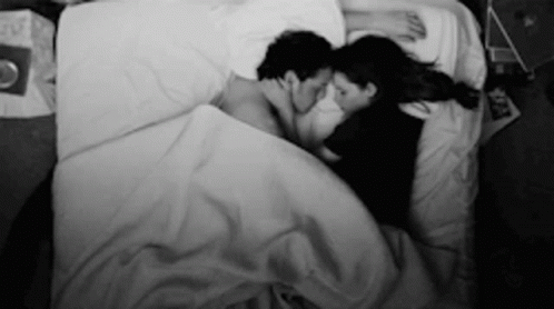 black and white pograph of two people in bed