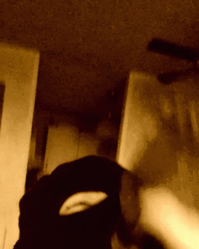 blurred image of a person with a knife in a dark room