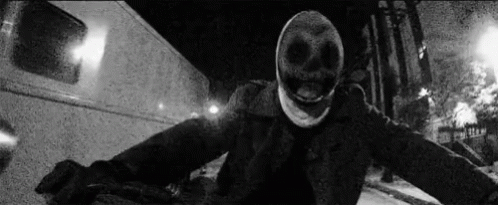 a person wearing a mask holding their hand up